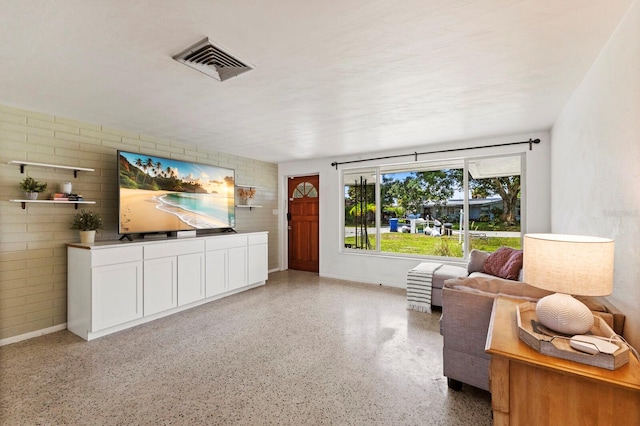 unfurnished living room with brick wall