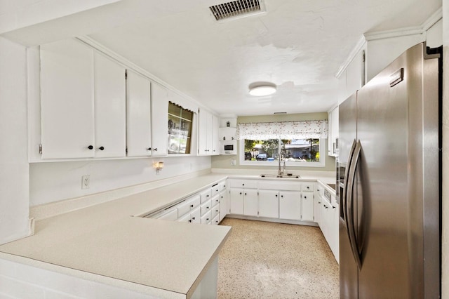 kitchen with white cabinets, kitchen peninsula, stainless steel fridge with ice dispenser, and sink