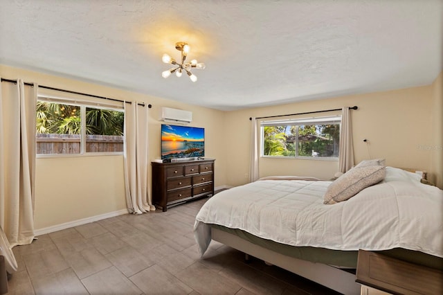 bedroom featuring a wall mounted air conditioner and an inviting chandelier