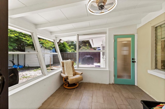 sunroom featuring vaulted ceiling with beams, plenty of natural light, and ceiling fan