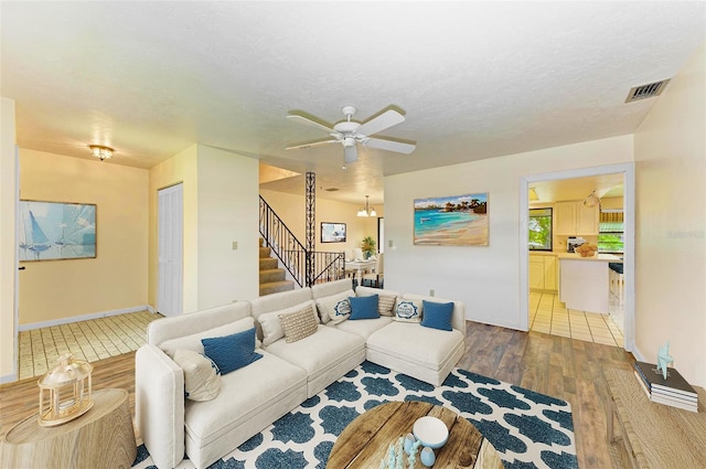 5111 Coral Blvd, Bradenton, FL 34210 - living room featuring light wood finished floors, stairs, ceiling fan, and baseboards