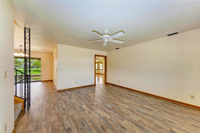 5111 Coral Blvd, Bradenton, FL 34210 - spare room featuring wood finished floors, a ceiling fan, baseboards, a textured ceiling, and a chandelier