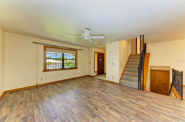 5111 Coral Blvd, Bradenton, FL 34210 - unfurnished living room with wood finished floors, baseboards, ceiling fan, and stairway