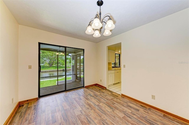 5111 Coral Blvd, Bradenton, FL 34210 - empty room with light wood-style flooring, a chandelier, baseboards, and a water view