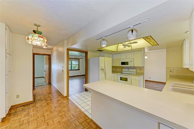 5111 Coral Blvd, Bradenton, FL 34210 - kitchen with white appliances, a peninsula, baseboards, light countertops, and a sink
