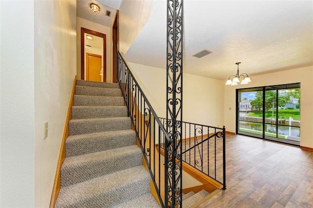 5111 Coral Blvd, Bradenton, FL 34210 - stairs with wood finished floors, a chandelier, and baseboards