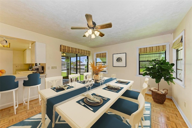 5111 Coral Blvd, Bradenton, FL 34210 - dining area with plenty of natural light, a textured ceiling, a ceiling fan, and baseboards