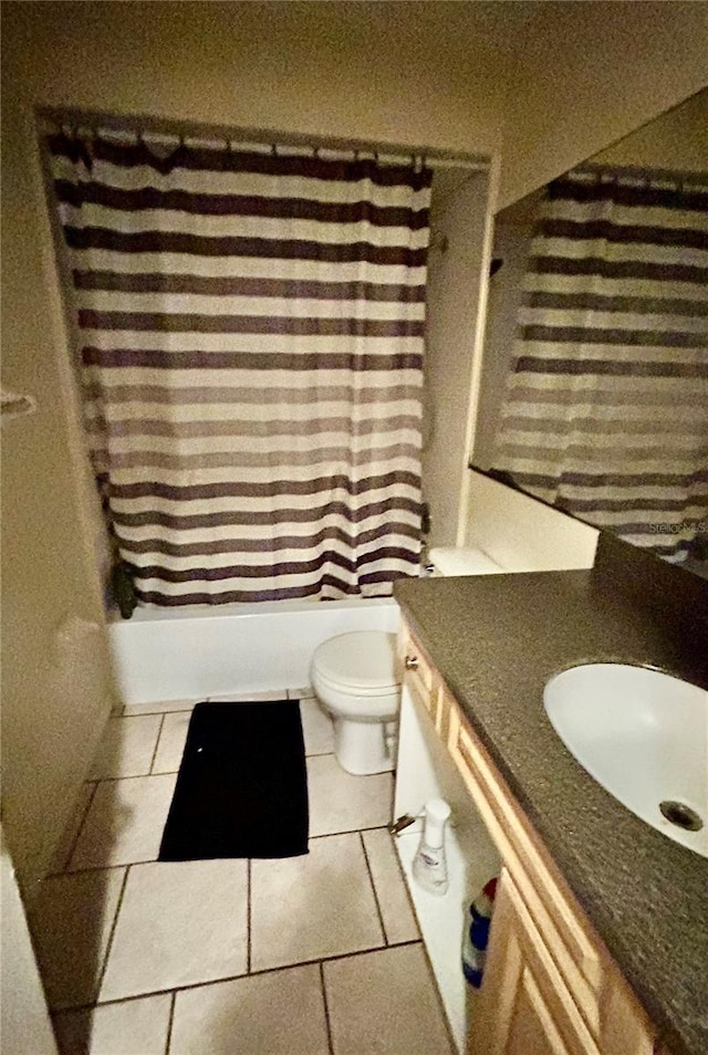 bathroom featuring toilet, tile patterned flooring, shower / bath combo with shower curtain, and vanity