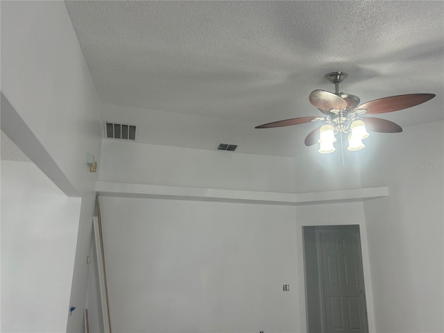 detailed view of ceiling fan and a textured ceiling