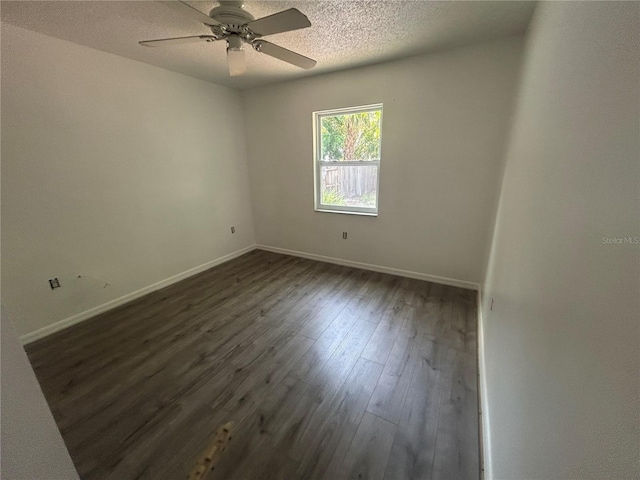 unfurnished room featuring dark wood-style floors, baseboards, a ceiling fan, and a textured ceiling