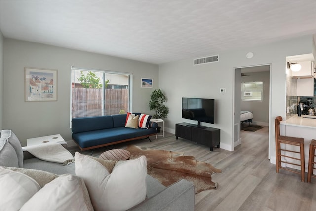 living room with sink and light hardwood / wood-style flooring