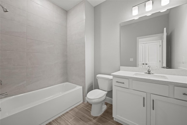 full bathroom featuring tiled shower / bath, vanity, and toilet