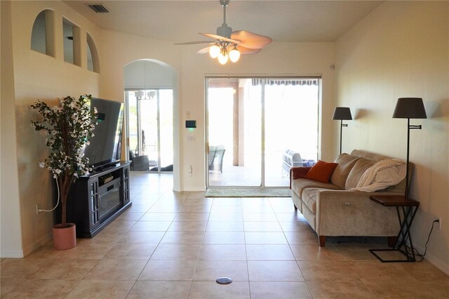 tiled living room with ceiling fan and vaulted ceiling