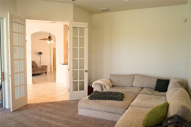 carpeted living room featuring ceiling fan, vaulted ceiling, and french doors