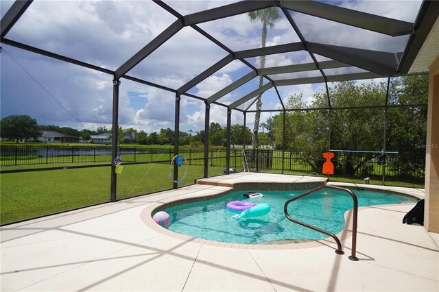 view of swimming pool featuring a patio area, a lanai, and a lawn