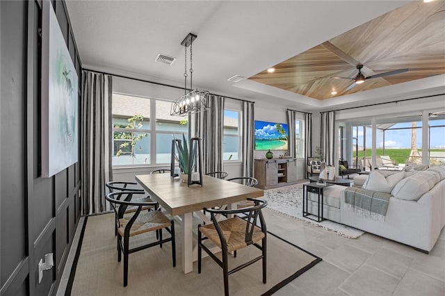 dining space with ceiling fan with notable chandelier, light tile patterned floors, a raised ceiling, and wood ceiling