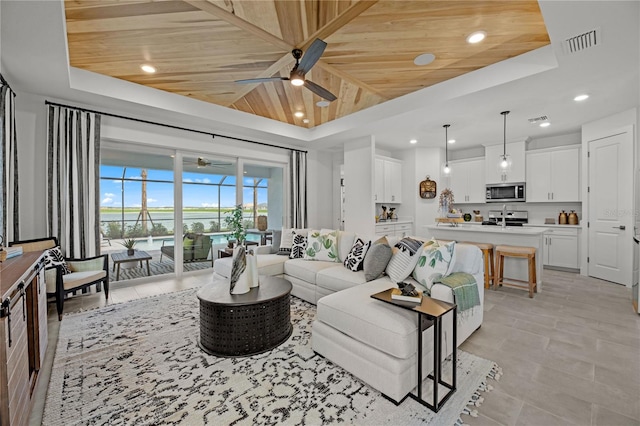 tiled living room with ceiling fan, a raised ceiling, and wood ceiling