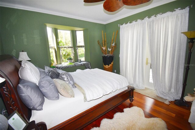 bedroom featuring hardwood / wood-style flooring, ornamental molding, and ceiling fan