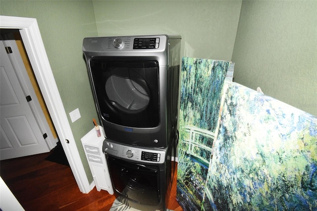 laundry area with hardwood / wood-style flooring and stacked washer / drying machine