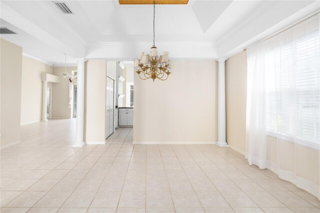 tiled spare room with crown molding, ornate columns, a chandelier, and a tray ceiling