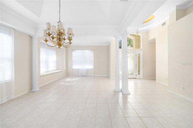 tiled spare room with decorative columns, a healthy amount of sunlight, a raised ceiling, and a chandelier