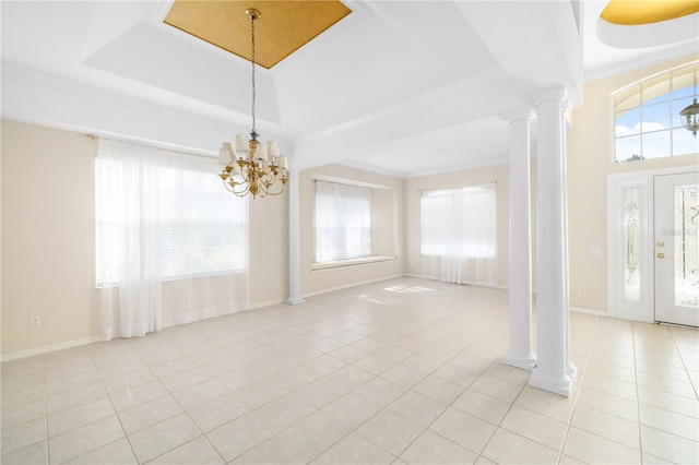 interior space with an inviting chandelier, a raised ceiling, decorative columns, and plenty of natural light