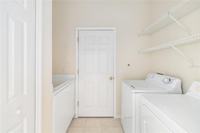 laundry area with light tile patterned flooring and washer and dryer