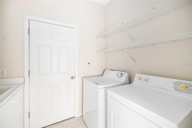 laundry room with washing machine and dryer and light tile patterned floors