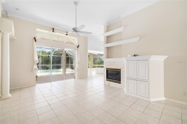 unfurnished living room with a fireplace, ceiling fan, a wealth of natural light, and light tile patterned floors