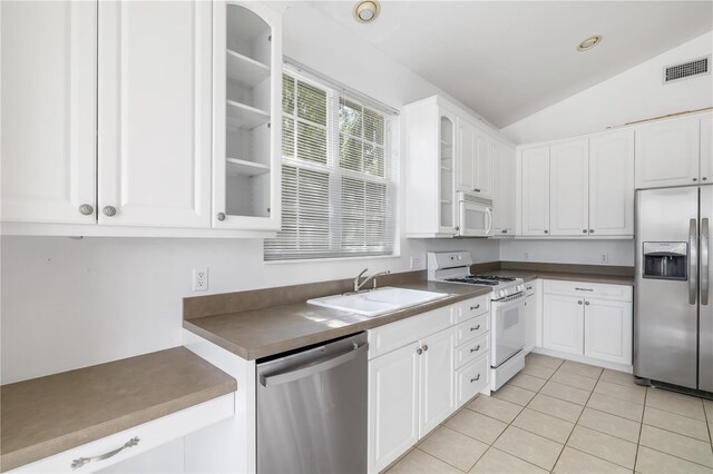 kitchen with sink, white cabinets, vaulted ceiling, and stainless steel appliances