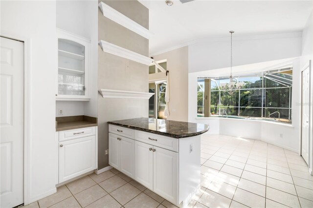 kitchen featuring white cabinetry, light tile patterned floors, dark stone countertops, vaulted ceiling, and kitchen peninsula