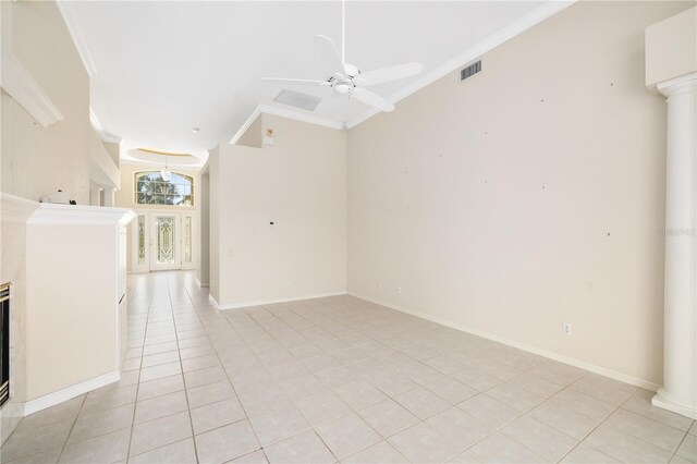 unfurnished living room with decorative columns, crown molding, ceiling fan, and light tile patterned floors