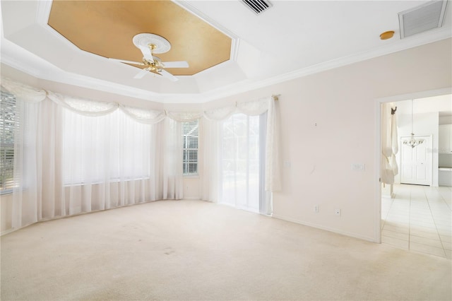 unfurnished room with plenty of natural light, light carpet, ceiling fan, and a raised ceiling