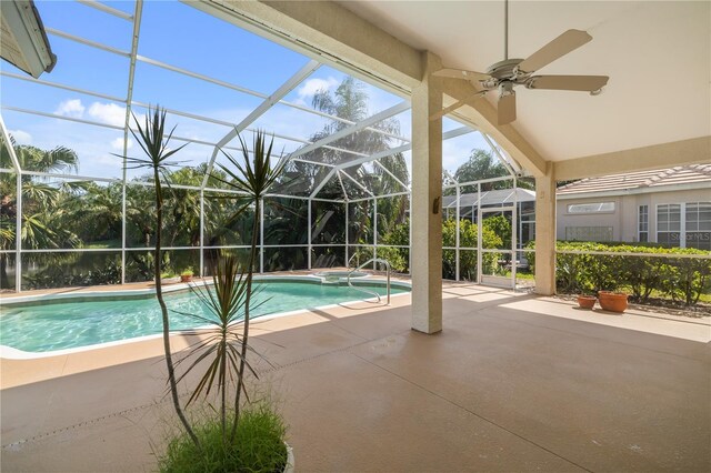 view of swimming pool featuring a patio area, ceiling fan, and glass enclosure