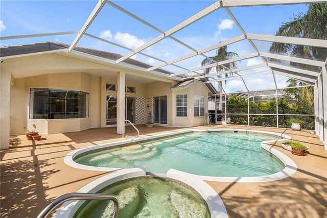 view of swimming pool with a patio, an in ground hot tub, and a lanai