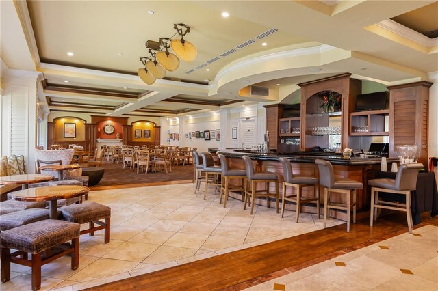 interior space with a tray ceiling, light wood-type flooring, ornamental molding, beam ceiling, and coffered ceiling