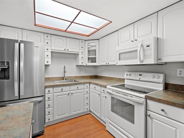 kitchen featuring white cabinetry, white appliances, and sink