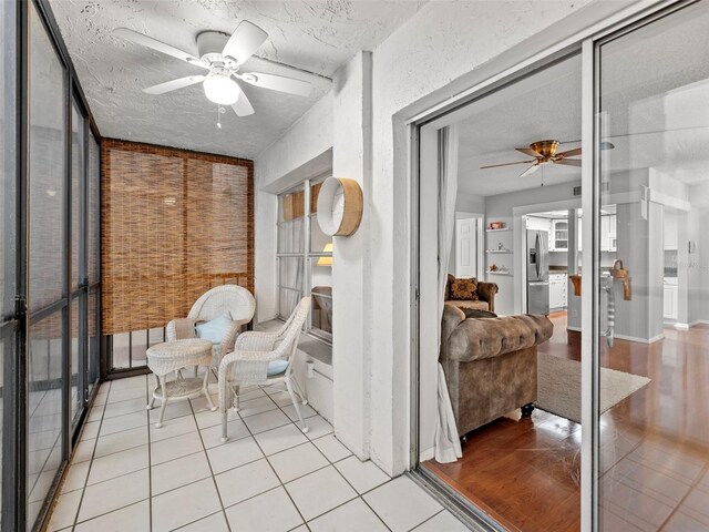 sunroom / solarium featuring ceiling fan