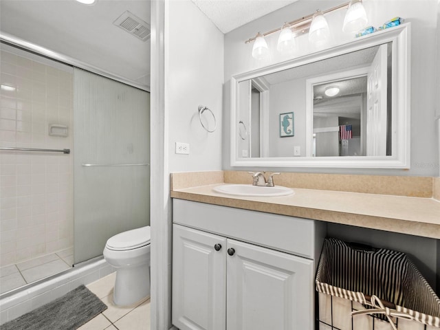 bathroom featuring tile patterned flooring, vanity, a shower with shower door, and toilet