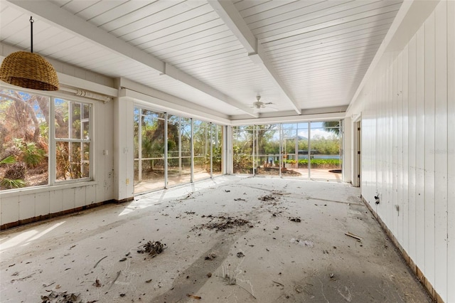 unfurnished sunroom with beam ceiling, ceiling fan, and plenty of natural light