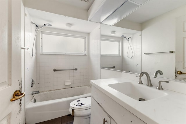 full bathroom featuring vanity, toilet, and tiled shower / bath