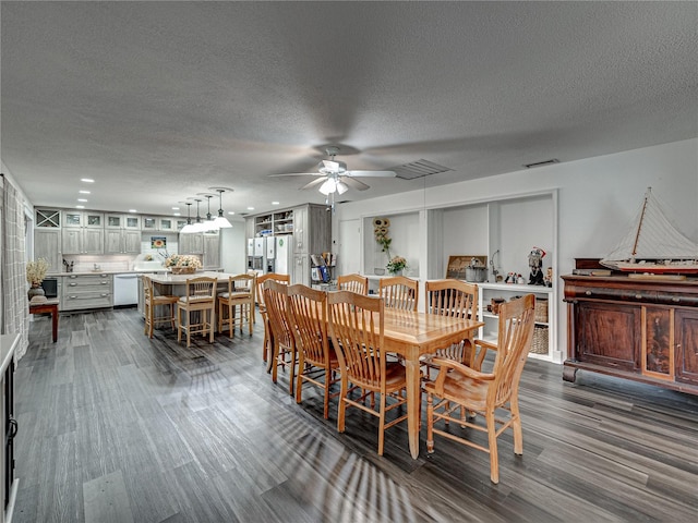 dining space featuring dark wood-type flooring, a textured ceiling, and ceiling fan