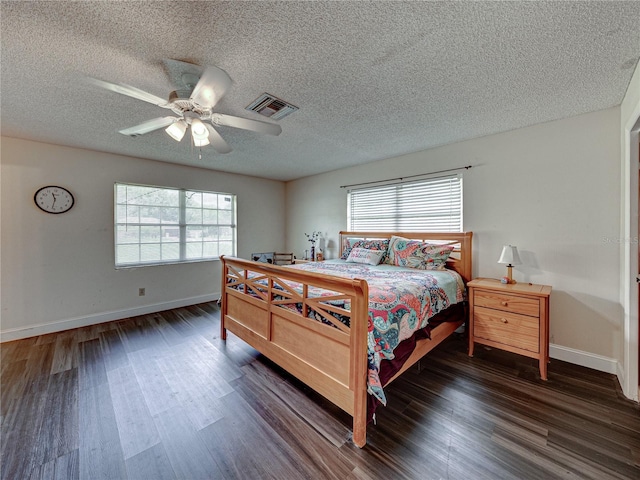 bedroom with dark wood-type flooring, a textured ceiling, and ceiling fan