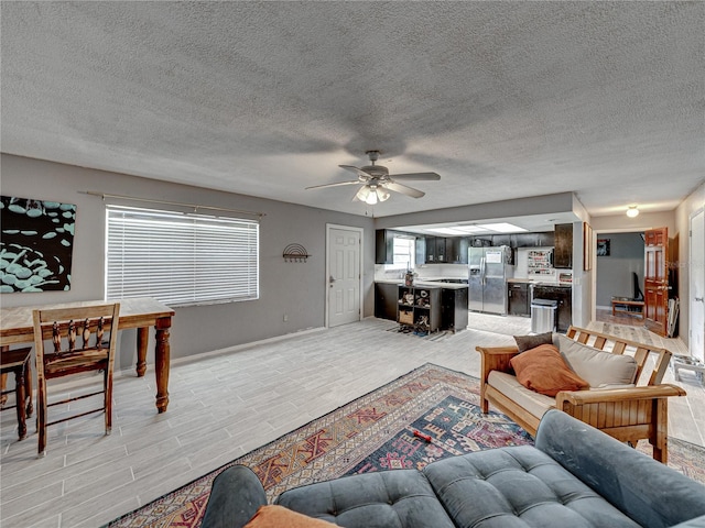 living room with light tile patterned flooring, a textured ceiling, and ceiling fan