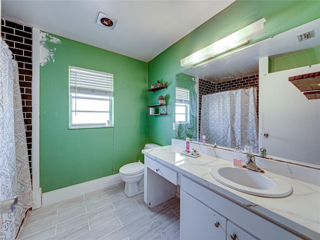 bathroom featuring a wealth of natural light, vanity, tile patterned floors, and toilet