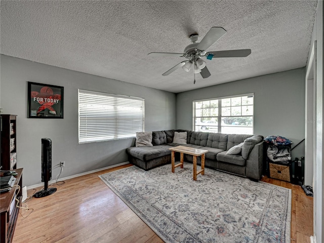 living room featuring a textured ceiling, ceiling fan, and light hardwood / wood-style floors