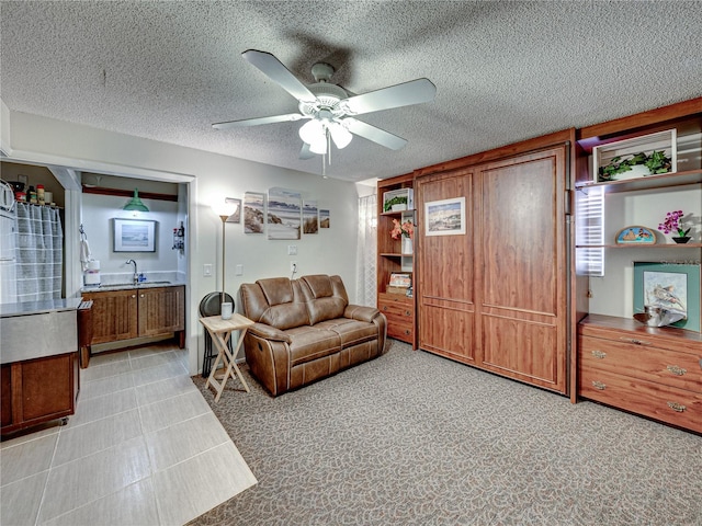 tiled living room with sink, a textured ceiling, and ceiling fan