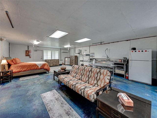 bedroom with a wall unit AC, white fridge, and concrete flooring