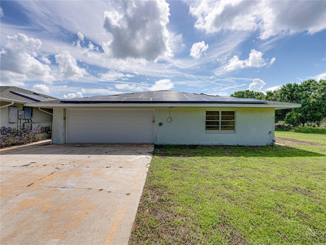 single story home featuring a front yard, electric panel, a garage, and solar panels