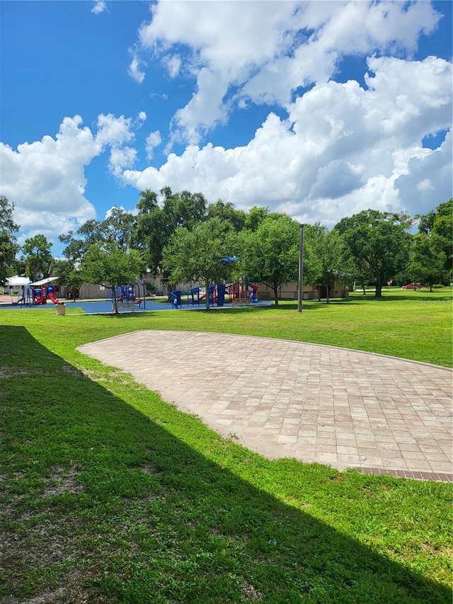 view of property's community with a playground and a lawn